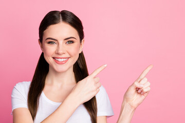 Closeup photo of pretty funny lady long hairdo tails directing finger side empty space demonstrating novelty product wear casual white t-shirt isolated pastel pink color background