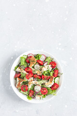 Delicious Fattoush or Arab salad with pita bread, fresh vegetables on plate. Middle Eastern bread...
