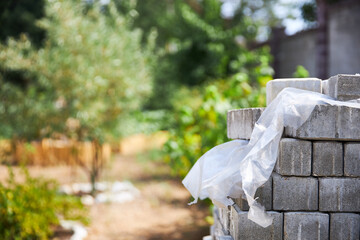 Close up of industrial bricklayer installing bricks on construction site on garden outdoor