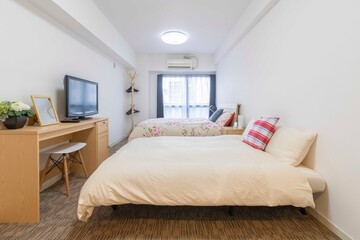 Twin bed and blanket in a small bedroom for couple people