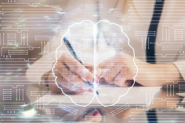 Multi exposure of woman's writing hand on background with brain hud. Concept of learning.