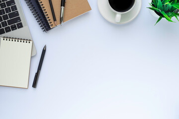 Top view above of White office desk table with laptop, notebook and coffee cup with equipment other office supplies. 