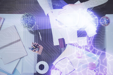 AR hologram over hands taking notes background. Concept of augmented reality. Double exposure