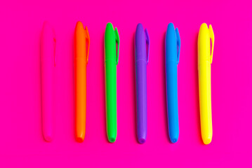 Magenta colored highlighters at magenta background with copy space