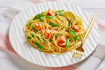 Salmon pasta with green beans on a white plate
