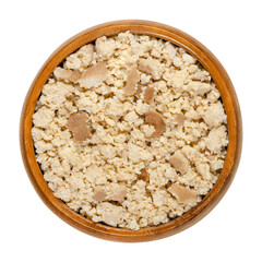 Smoked tofu, bean curd, crumbled by hand, in a wooden bowl. Coagulated soy milk, a component of Asian cuisine and meat substitute. Close-up from above, on white background, isolated macro food photo.