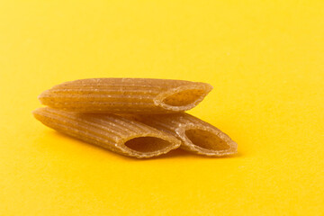 Pasta from hard wheat. Italian pasta on yellow background,  place for text.