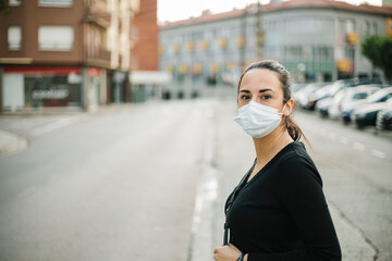 Young woman in medical face mask for Coronavirus prevention in the street