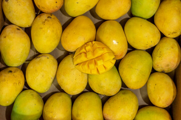 Famous Alphonso mango slices over mangoe background, Top view