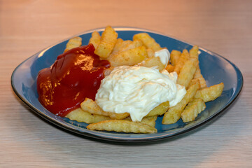 A typical german meal - Pommes rot weiss: french fries with mayo and ketchup