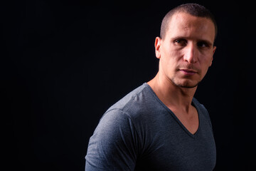 Face of man with short hair against black background