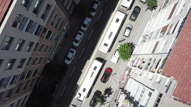 Aerial view of the public buses at the city center. Vehicles are waiting at the red light. Camera is spinning to the left side.