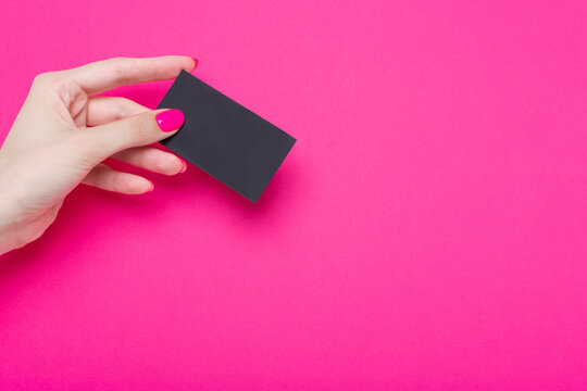 Woman's Hands Hold Blank Business Card Isolated On Pink Paper