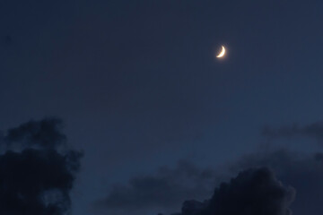 Naklejka na ściany i meble A scenic shot of the crescent moon shining in the cloudy night sky