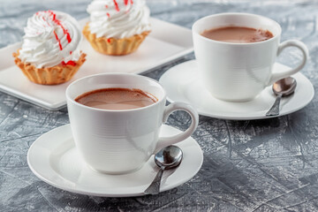 Freshly brewed aromatic coffee with cream and cake on gray background