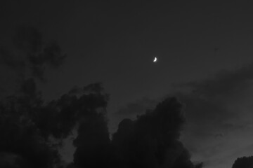 Fototapeta premium A scenic shot of the crescent moon shining in the cloudy night sky