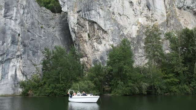Small Boat Moored Next to a Big Cliff, Rock Formation in the River Meuse, Belgium