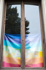 Multicolored bright rainbow lgbt pride flag in the window of the house.