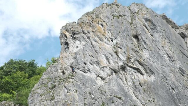 Rock Climber Making His Way Up a Cliff during Sunny Summer Day
