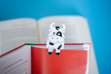 book with paper cow bookmarks , soft focus