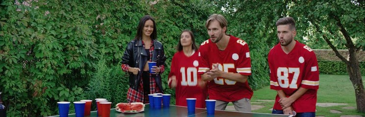 Diverse group of students friends playing beer pong game outside in summer, spring break games, college life. Shot on RED cinema camera with 2x Anamorphic lens