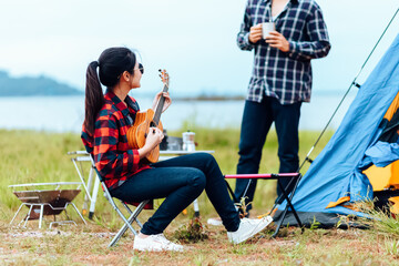 Group of friends camping and they are sitting playing guitar. Camp and music guitar concept.