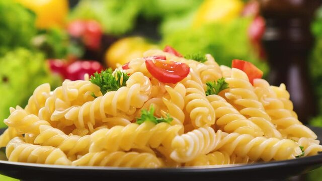 Plate of italian fusilli pasta with tomatoes and basil leaves, 4K UHD video footage