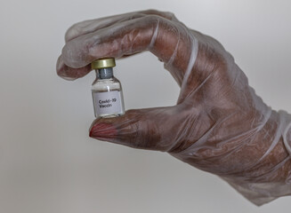 holding a small bottle with covid-19 vaccin