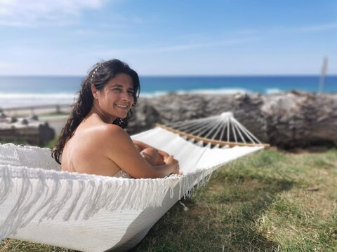 
Pretty woman enjoying, resting in the summer sun in a hammock