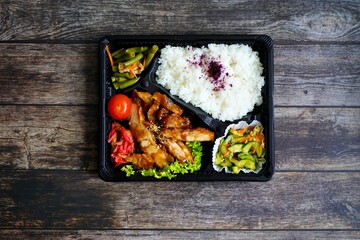 Colorful Japanese „Toriteri“ bento box with grilled chicken and teriyaki sauce, rice and...