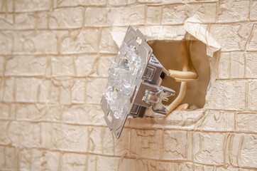 Part of the light switch attached to the wires in the wall close-up, copy space