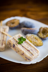 plum sweet homemade ice cream on a stick with slices of plum inside, in a plate