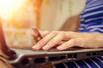 Close-up of a woman's hands holding a credit card and using a laptop. concept of online shopping