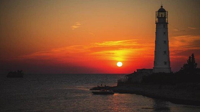 Amazing colourful time lapse sunset at ocean near old Lighthouse and sunken ship
