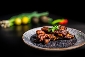 Close-up freshly made smoked glazed paprika Ribs in a serving plate with vegetables in the background. Concept of serving cooked rib meal.