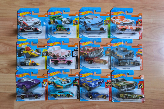 Istanbul, Turkey - July 29, 2020 : 12 Hot Wheels die cast toy cars in blisters on wooden floor from directly above view .