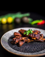 Close-up freshly made smoked glazed paprika Ribs in a serving plate with vegetables in the background. Concept of serving cooked rib meal.