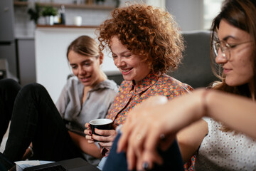 Happy businesswomen talking and laughing in office. Beautiful women on coffee break..