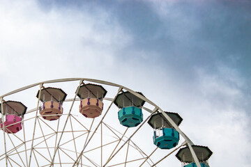 Ferris wheel on cloudy sky background