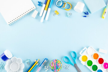 Various school office and painting supplies on blue background. Back to school concept. Top view. Copy space