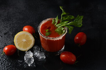 Glass of fresh tomato juice and tomatoes on Dark background with water drops