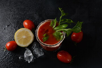 Glass of fresh tomato juice and tomatoes on Dark background with water drops