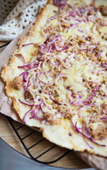 Very tasty and delicious pizza with tuna, red onion, cheese. Thin Italian pastry. Close-up, top view.