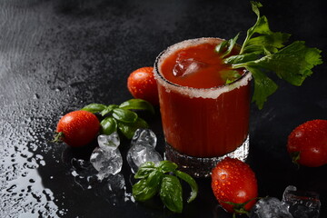 Glass of fresh tomato juice and tomatoes on Dark background with water drops