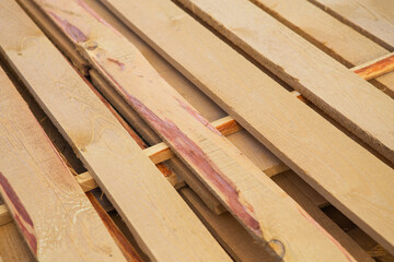 Building material in the form of fresh wooden planks at a road repair site. The repair process. View from above.
