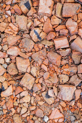 A pile of old broken red clay brick rubble after demolition of an old building lies on the ground on a building site.