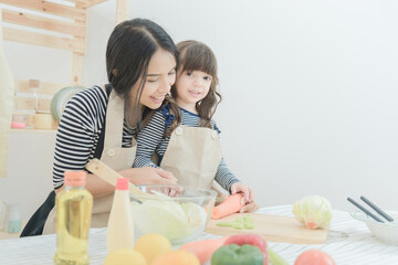 Happy loving family asian mother and her daughter prepare healthy food salad in kitchen room.Photo...