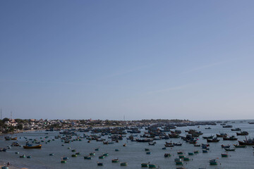 Fototapeta na wymiar MUI NE / VIETNAM - December 28, 2019 : view on Fishing village and traditional fishing boat with hundreds boats anchored ( fishing harbour market)