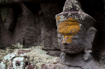 Small Buddha face carving adorned with coloured paste