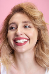 Smiling. Caucasian young woman's close up portrait isolated on pink studio background. Beautiful blonde model. Concept of human emotions, facial expression, sales, ad, youth. Copyspace.